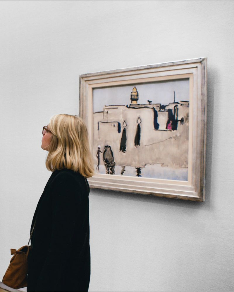A visitor studying a framed painting