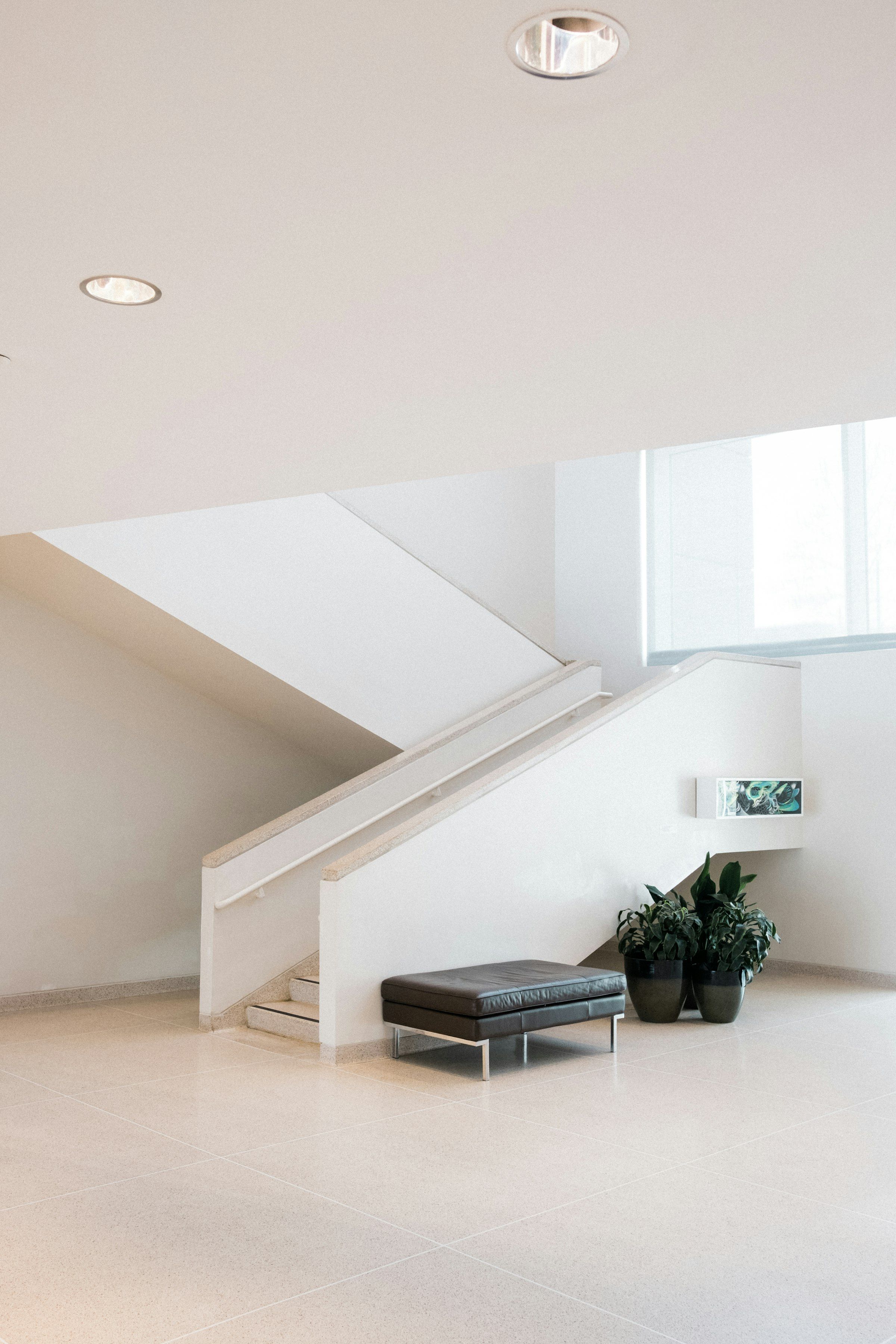 A white gallery staircase lit from a skylight